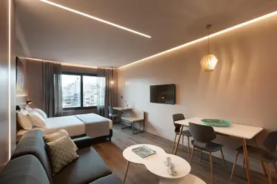 a hotel room with a bed and a couch and tables at City Lights Athens by YHA in Athens