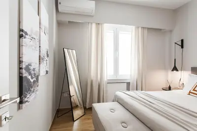 a white bedroom with a bed and a window at Peaceful 2BD Apartment in Kolonaki by UPSTREET in Athens