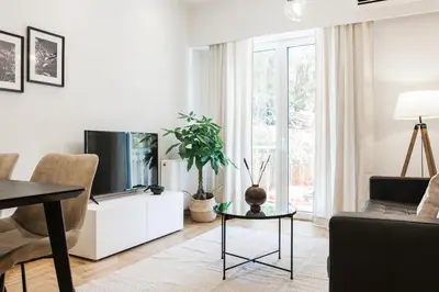 a living room with a tv and a table at Peaceful 2BD Apartment in Kolonaki by UPSTREET in Athens
