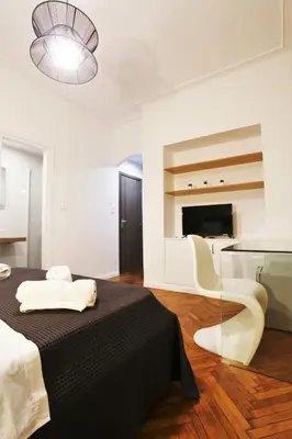 a bedroom with a bed and a table and a television at GK Niki by GK Properties in Athens