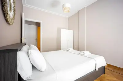 a bedroom with a white bed with white pillows at GK Niki by GK Properties in Athens