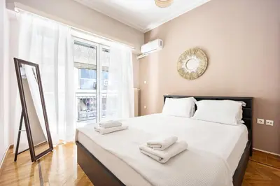 a bedroom with a large white bed with towels on it at GK Niki by GK Properties in Athens