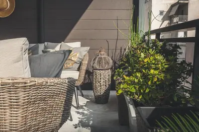 a patio with wicker chairs and potted plants at Sea view super romantic apartment in Athens