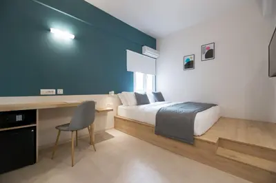a bedroom with a bed and a desk with a chair at The Convo Athens Riviera in Athens