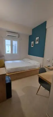 a bedroom with a large bed and a window at The Convo Athens Riviera in Athens