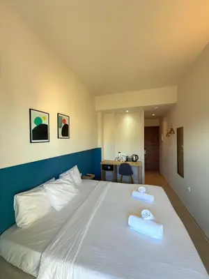 a bedroom with a large white bed with towels on it at The Convo Athens Riviera in Athens