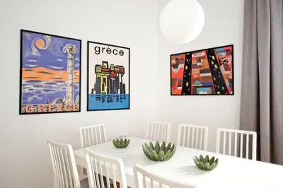 a dining room with a white table and four paintings at Art in Athens Suite in Athens