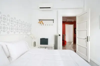 a white bedroom with a white bed and a door at Art in Athens Suite in Athens