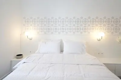 a bedroom with a white bed with two white pillows at Art in Athens Suite in Athens