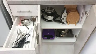 an open kitchen cabinet with utensils in it at Cozy Little Home in Athens