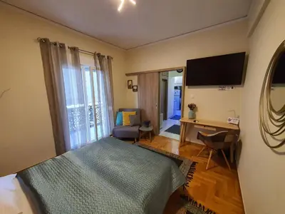 a bedroom with a bed and a desk and a television at Cozy Little Home in Athens