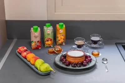 a table with fruits and juice and a plate of food at Olygreen Athens Residences in Athens