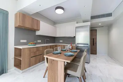 a kitchen with a wooden table and chairs at Olygreen Athens Residences in Athens