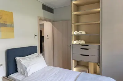 a bedroom with a bed and a closet at Olygreen Athens Residences in Athens