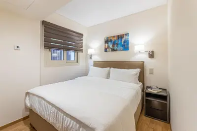 a bedroom with a white bed and a window at Olygreen Athens Residences in Athens
