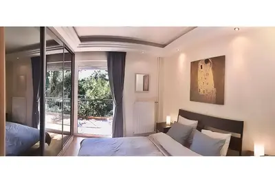 a bedroom with two beds and a large window at A1 Elegant Vouliagmeni apt in a Unique Spot in Athens