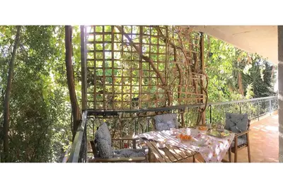a table and chairs on a balcony with a pergola at A1 Elegant Vouliagmeni apt in a Unique Spot in Athens