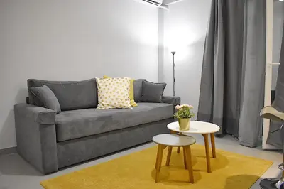 a living room with a gray couch and a table at Check Point - Acropolis in Athens