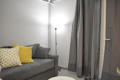 a living room with a gray couch with yellow pillows at Check Point - Acropolis in Athens