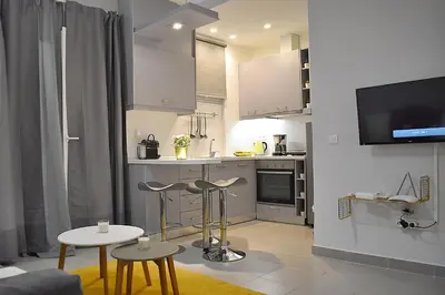 a kitchen with white cabinets and stools in a room at Check Point - Acropolis in Athens