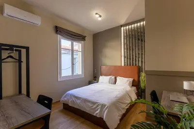 a bedroom with a bed and a desk and a window at NOHO Boutique , premium living Dikeou 8 in Athens