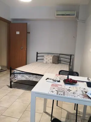 a bedroom with a bed and a table and a table and chairs at House in the center of Piraeus next to the port and the metro!! in Piraeus