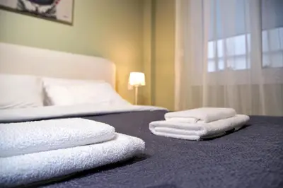 two stacks of towels on a bed in a bedroom at Your Attiki Home VIPGreece in Athens