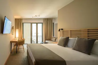 a hotel room with a large bed and a desk at Fos DownTown Suites in Athens