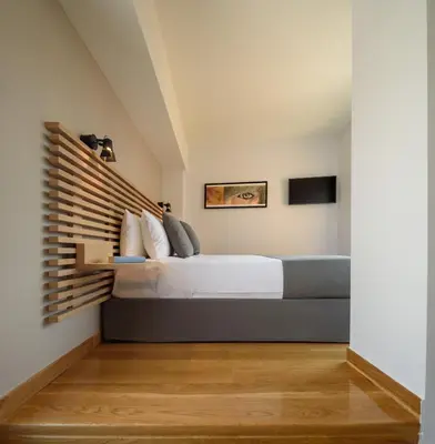 a bedroom with a bed with a wooden headboard at Fos DownTown Suites in Athens