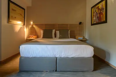 a bedroom with a large bed with a wooden headboard at Fos DownTown Suites in Athens