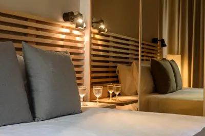 a bedroom with a bed with a mirror and a couch at Fos DownTown Suites in Athens