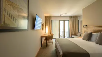 a hotel room with a bed and a desk at Fos DownTown Suites in Athens