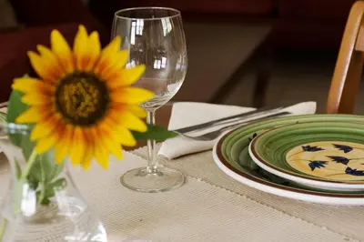 a table with a yellow sunflower and a wine glass at Apartment in Peania (15min from Airport) in Paianía