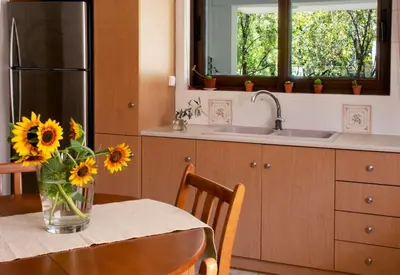 a kitchen with a table with a vase of sunflowers at Apartment in Peania (15min from Airport) in Paianía