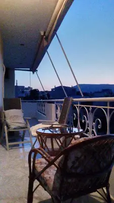 a table and chairs on a balcony with a view at Stamatis Big Apartment in Spáta