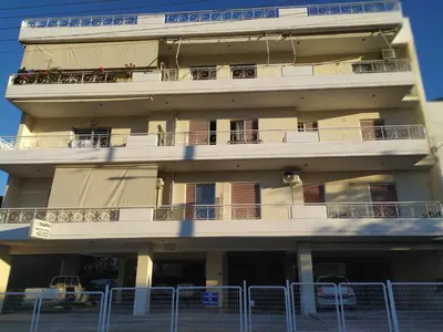 a building with balconies and a fence in front of it at Stamatis Big Apartment in Spáta