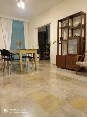 a living room with a table and chairs and a dining room at Stamatis Big Apartment in Spáta