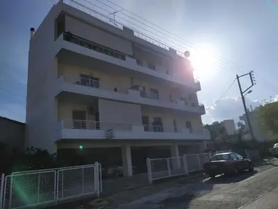 a white building with a car parked in front of it at Stamatis Big Apartment in Spáta
