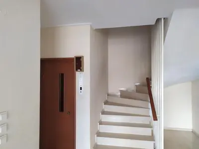 a hallway with stairs and a wooden door at Stamatis Big Apartment in Spáta
