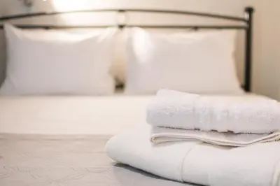 a pile of towels sitting on top of a bed at SEASIDE SUNSET WALKS in Athens