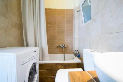 a bathroom with a washing machine and a bath tub at SEASIDE SUNSET WALKS in Athens