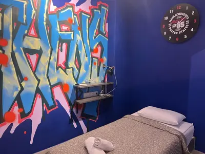 a bedroom with a colorful wall with a bed and a clock at Cyber Loft - Futuristic Athens VIPGreece in Athens