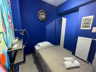a blue bedroom with a bed and a clock on the wall at Cyber Loft - Futuristic Athens VIPGreece in Athens
