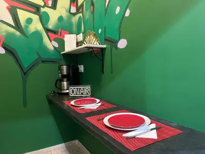 a table with plates and napkins on a green wall at Cyber Loft - Futuristic Athens VIPGreece in Athens