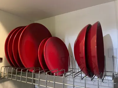 four red plates on a rack in a kitchen at Cyber Loft - Futuristic Athens VIPGreece in Athens