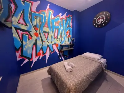 a bedroom with a bed with a painting on the wall at Cyber Loft - Futuristic Athens VIPGreece in Athens