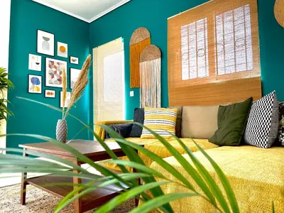 a living room with blue walls and a couch at Bohem Apartment near Athens Airport in Spáta