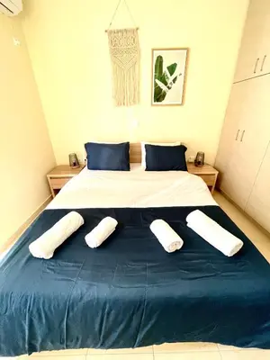 a bedroom with a large bed with three pillows on it at Bohem Apartment near Athens Airport in Spáta
