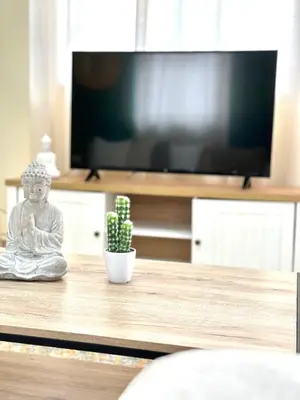 a statue sitting on a table in front of a tv at Bohem Apartment near Athens Airport in Spáta
