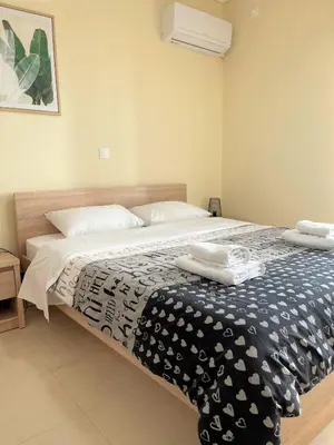 a bedroom with a bed with a black and white blanket at Boho Apartment near Athens Airport in Spáta